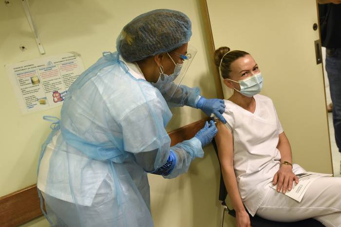 Erika Correa, trabajadora de la salud recibe la vacuna contra el Covid 19, de parte de una colega en la mutualista Médica Uruguaya.  · Foto: Federico Gutiérrez