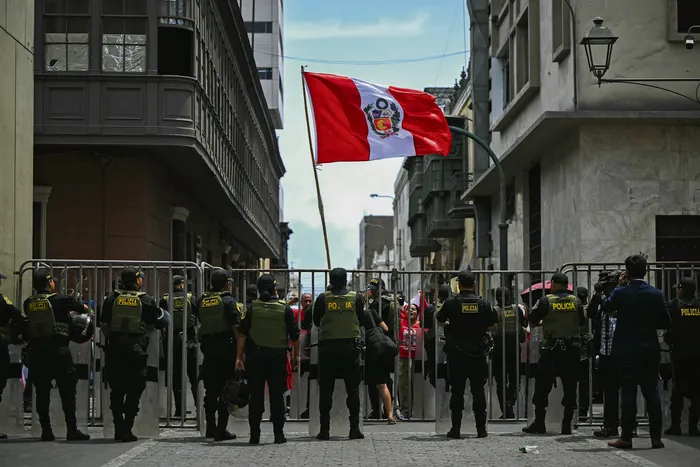 Policías montan guardia durante una manifestación en las afueras del edificio Faustino Sánchez Carrión del Poder Legislativo, mientras el Congreso de Perú destituía al expresidente José Jeri, el 17 de febrero. · Foto: Ernesto Benavides, AFP
