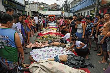 Pobladores de Vila Cruzeiro, en la plaza San Lucas, junto a los cuerpos de personas muertas durante la operación policial llevada a cabo el 29 de octubre. · Foto: Pablo Porciúncula, AFP
