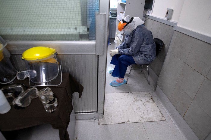 Trabajador de la morgue espera para retirar el cadáver que falleció por coronavirus, en el Centro de Tratamiento Intensivo, en un hospital privado de Montevideo, el 4 de junio de 2021. · Foto: Pablo Porciúncula, AFP.