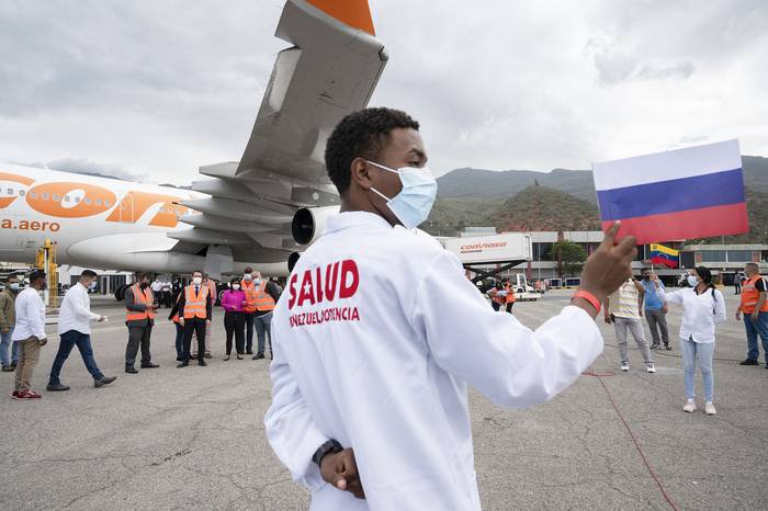 Trabajador de la salud venezolano, asiste a la llegada de 100.000 dosis de la vacuna rusa Sputnik V, en el Aeropuerto Internacional Simón Bolívar de La Guaria, el 13 de febrero, en Venezuela.  · Foto: Yuri Cortez, AFP