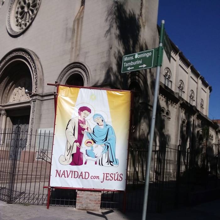 Una pancarta de la campaña de la iglesia católica Navidad con Jesús invisibiliza la placa colocada en la parroquia San Juan Bautista, en Pocitos.
Foto: Gentileza Comisión Memoria Sacerdote Mauricio Silva.