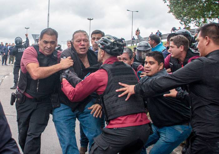 Sergio Berni (2i) es escoltado luego de resultar herido durante una protesta, el 3 de abril, en La Matanza, provincia de Buenos Aires. · Foto: Stringer, Efe