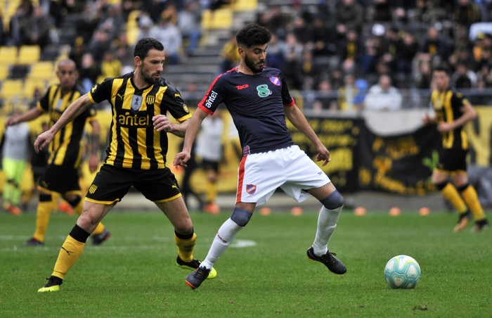 Maximiliano Rodríguez, de Peñarol, y Rodrigo Cabrera, de Atenas, en el estadio Campeón del Siglo.  · Foto: Federico Gutiérrez