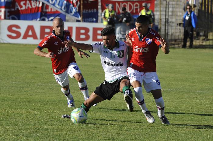  Gustavo Lorenzetti, de Nacional,  Ányelo Rodriguez, de Racing y Santiago Rodriguez, de Nacional, en el estadio José Nasazzi. 
 · Foto: Federico Gutiérrez