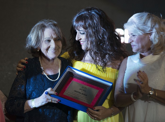 Cristina Morán recibe el premio a la trayectoria de manos de Virginia Moreira (d), junto a su hija Carmen, en la entrega de los premios Florencio 2018. · Foto: Santiago Mazzarovich Cristina Morán recibe el premio a la trayectoria de manos de Virginia Moreira (d), junto a su hija Carmen, en la entrega de los premios Florencio 2018. · Foto: Santiago Mazzarovich
