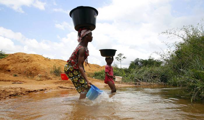 Habitantes de Abiyán, Costa de Marfil, se abastecen de agua de río, el 21 de marzo. · Foto: Legnan Koula, EFE