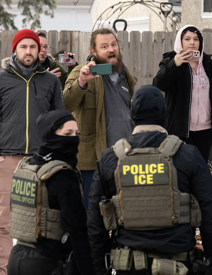 Ciudadanos y agentes del ICE que mantienen un perímetro después de que uno de sus vehículos sufriera una pinchadura en Penn Avenue, el 5 de febrero. · Foto: Stephen Maturen, Getty Images, AFP