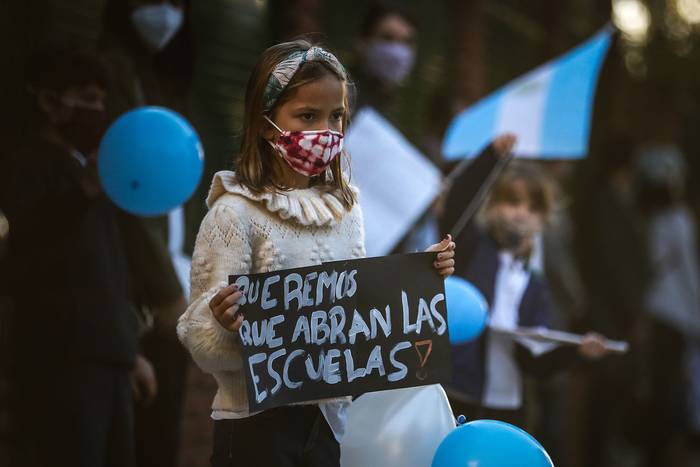Padres y alumnos se manifiestan frente a colegios para reclamar la reapertura de clases presenciales. · Foto: Juan Ignacio Roncoroni, pool, AFP