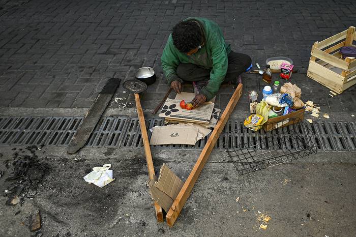Una persona prepara comida en una calle de Buenos Aires (28.09.2022). · Foto: Luis Robayo, AFP