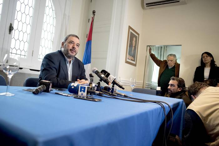 Mario Bergara, ayer, en la sede del Frente Amplio, durante la conferencia de prensa en la que anunció su precandidatura presidencial. Atrás, José Mujica.  · Foto: Ricardo Antúnez