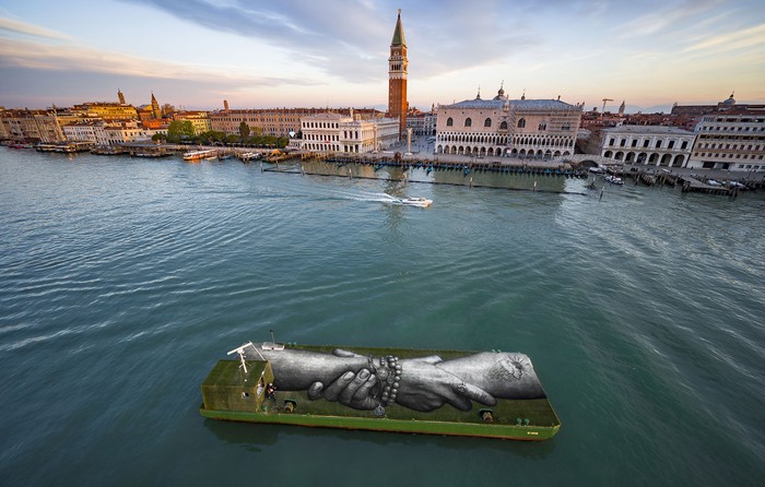 Pintura biodegradable del artista Saype, del proyecto Beyond Walls en una barcaza en Venecia, Italia. · Foto: Valentin Flauraud, Saype, AFP