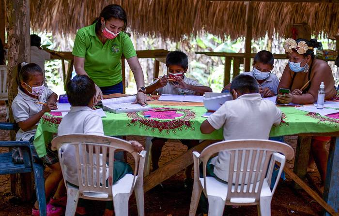 La maestra Graciela Bouche (i) durante una clase con niños indígenas Embera, el 9 de marzo, en la comunidad de Ella Puru Embera, provincia de Colón, Panamá.
 · Foto: Luis Acosta, AFP