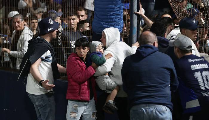Reacción del público a los gases lacrimógenos lanzados por la policía, el 6 de octubre, en el Estadio Juan Carmelo Zerillo, en La Plata. · Foto: Alejandro Pagani, AFP.