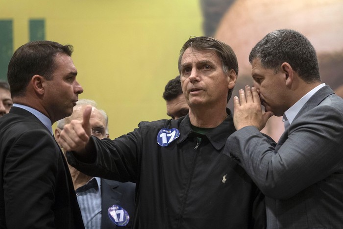 Jair Bolsonaro, el presidente del Partido Social Liberal Gustavo Bebianno (der.) y Flavio Bolsonaro (izq.), senador electo en Río de Janeiro, el 11 de octubre, durante una conferencia de prensa. · Foto: Mauro Pimentel, AFP