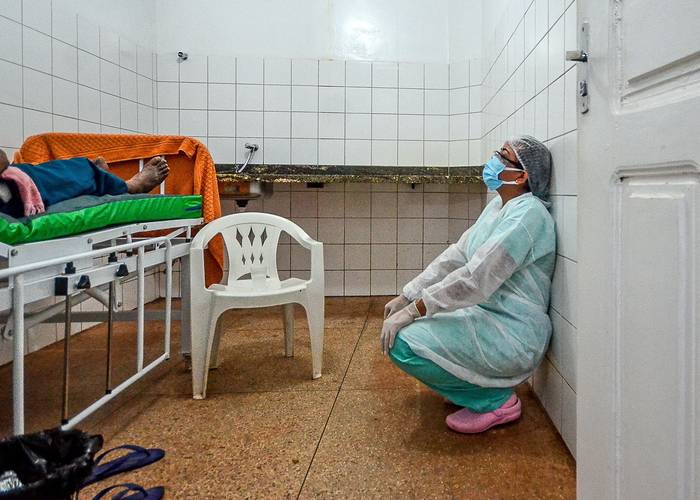 Una doctora descansa luego de proveer oxígeno a un paciente con covid, en un hospital improvisado a orillas del río Moju, en el estado de Pará, Brasil.
  · Foto: Joao Paulo Guimaraes, AFP