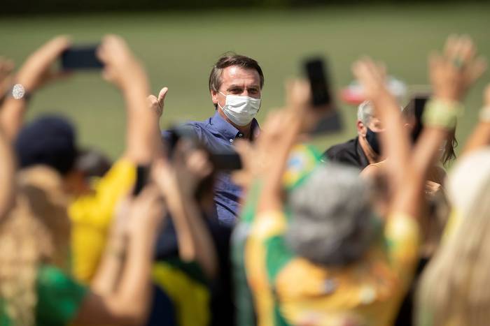 Jair Bolsonaro saluda a simpatizantes que celebran su cumpleaños 66, ayer, frente al Palacio de la Alvorada, en Brasilia.
 · Foto: Joédson Alves, EFE