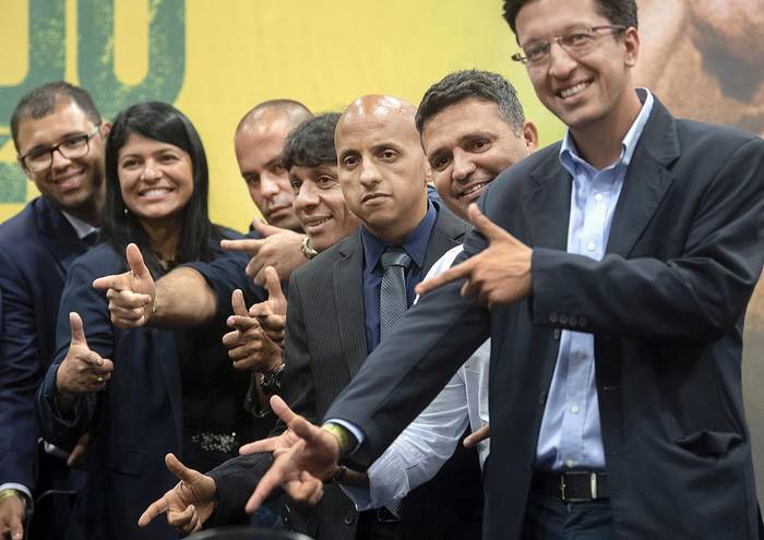 Durante la conferencia de prensa de Jair Bolsonaro el 11 de octubre en Río de Janeiro, legisladores
y miembros del Partido Social Liberal (PSL) imitan el conocido gesto de disparar con un arma de
su líder.  · Foto: Mauro Pimentel