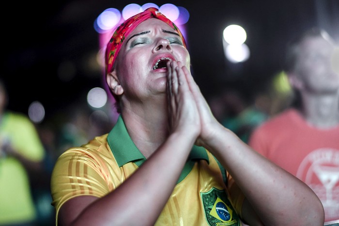 Una mujer observa el partido entre Brasil y Bolivia en la plaza Mauá, en Río de Janeiro, Brasil. · Foto: Mauro Pimentel