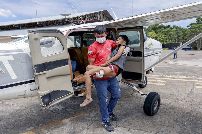 Un profesional de la salud lleva a un paciente yanomami, el 29 de enero, a la ciudad de Boa Vista, estado de Roraima, Brasil. · Foto: Michael Dantas, AFP