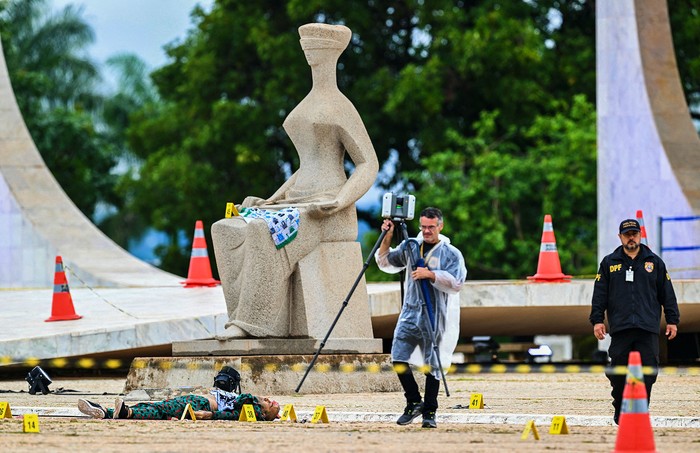 Forenses de la Policía Federal de Brasil junto al cuerpo de un hombre que intentaba atacar la Corte Suprema de Brasil, el 13 de noviembre, en Brasilia. · Foto: Evaristo Sa, AFP