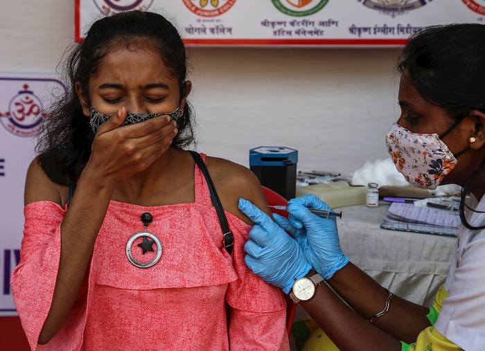 Una niña reacciona mientras recibe la inyección de la vacuna covid-19 en el instituto Chogle de Borivali, en Mumbai (India), el 17 de enero de 2022. · Foto: Divyakant Solanki, Efe