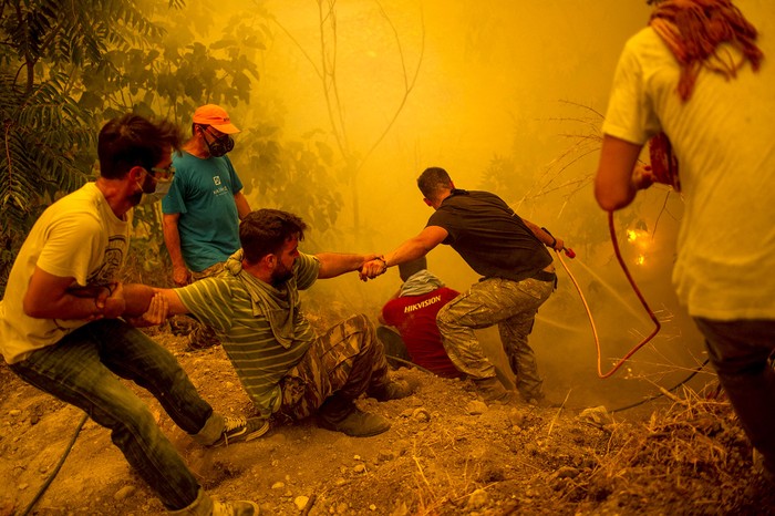 Residentes del pueblo de Gouves en la isla de Evia, la segunda isla mas grande de Grecia, luchan para controlar los incendios forestales en la isla. · Foto: Angelos Tzortzinis, AFP