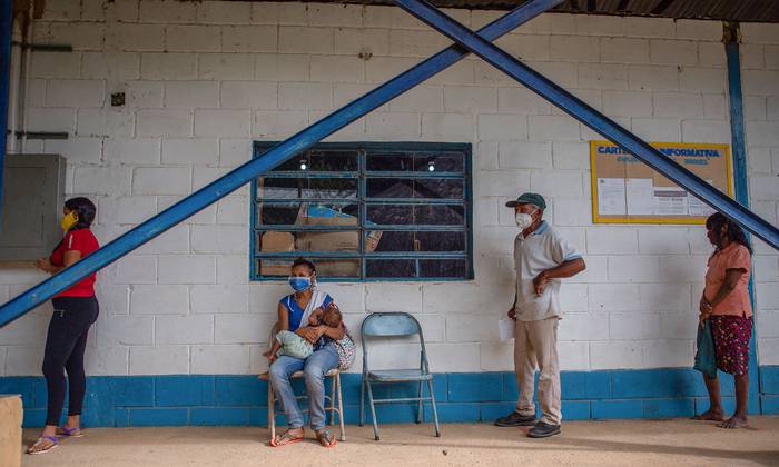 Personas pertenecientes a la etnia E'ñepa esperan una consulta en el ambulatorio rural La Milagrosa, el 17 de enero, en el estado Bolívar, Venezuela. · Foto: Federico Parra, AFP