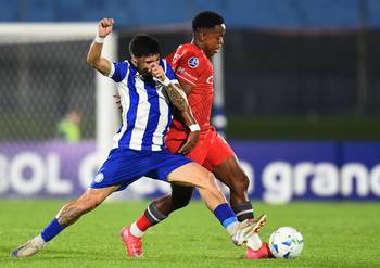 Julián Contrera, de Cerro Largo, y Alex Rodríguez, de la Universidad Católica, el 7 de mayo, en el estadio Centenario. · Foto: Dante Fernández, AFP