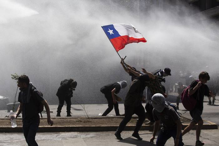 Los manifestantes se enfrentan con la policía antidisturbios durante una protesta en Santiago, el 21 de octubre de 2019.  · Foto: Claudio Reyes, AFP