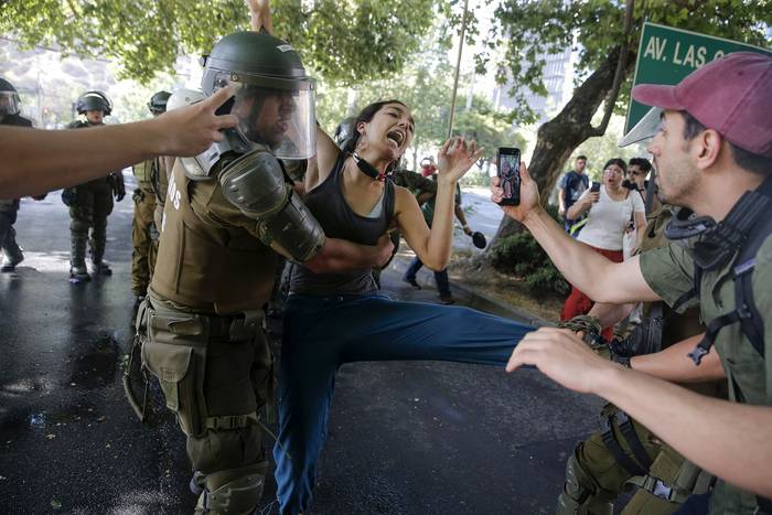 La policía antidisturbios choca con los manifestantes durante una protesta cerca de la casa del presidente chileno Sebastián Piñera en Santiago, el 1 de diciembre de 2019. · Foto: Javier Torres AFP