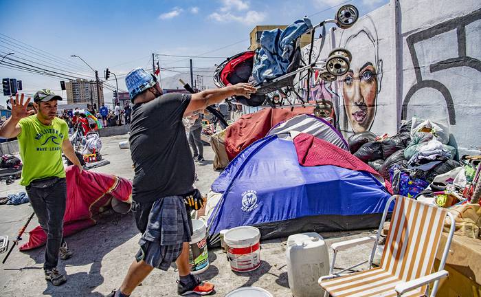 Manifestantes destruyen un campamento improvisado de inmigrantes venezolanos, el sábado, durante una marcha de protesta contra la inmigración ilegal en Iquique, Chile. · Foto: Martin Bernetti / AFP