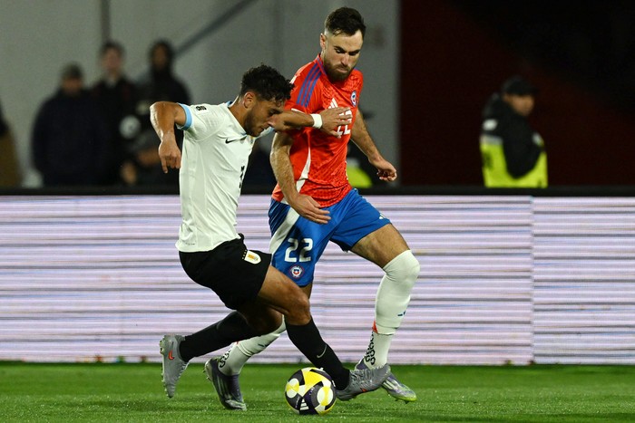 Sebastián Cáceres, de Uruguay y Ben Brereton, de Chile, el 9 de setiembre, en el estadio Julio Martinez Pradanos, en Santiago. · Foto: Rodrigo Arangua, AFP