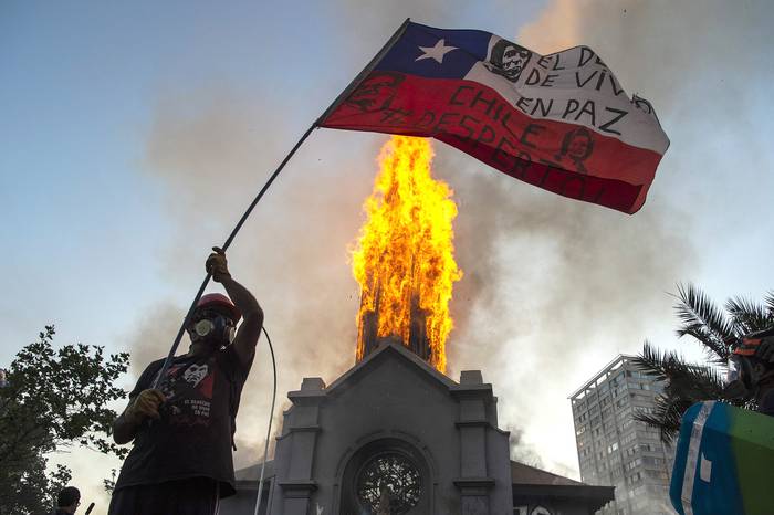 Iglesia de Asunción, incendiada por los manifestantes, en la conmemoración del primer aniversario del levantamiento social en Chile, el 18 de octubre, en Santiago. · Foto: Martin Bernetti / AFP