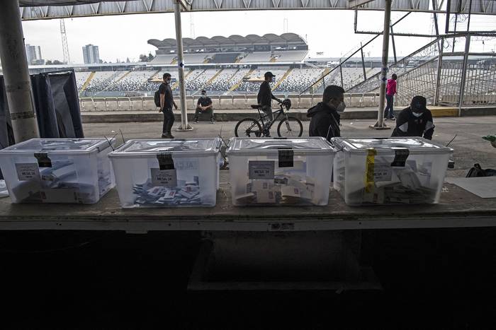 Mesa de votación de las elecciones para elegir alcaldes, concejales y una asamblea para redactar la Constitución, en el Estadio Monumental de Santiago. · Foto: Martín Bernetti, AFP