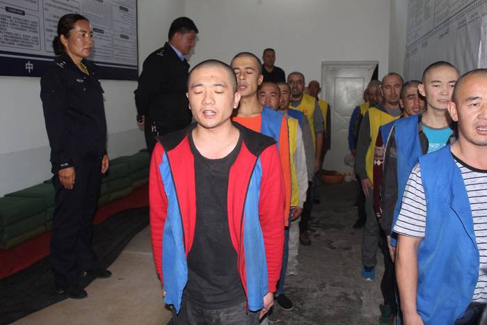 Imagen sin fecha de detenidos custodiados por la policía en el centro de detención del condado de Tekes en la región de Xinjiang, en el oeste de China. Foto: Fundación Memorial a las Víctimas del Comunismo, AFP.