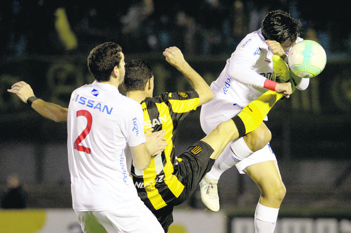 Maximiliano Rodríguez, de Peñarol (c), y Agustín Rogel (i) y Gonzalo Porras, de Nacional, en el último clásico.
Foto: Andrés Cuenca (archivo,
agosto de 2017)