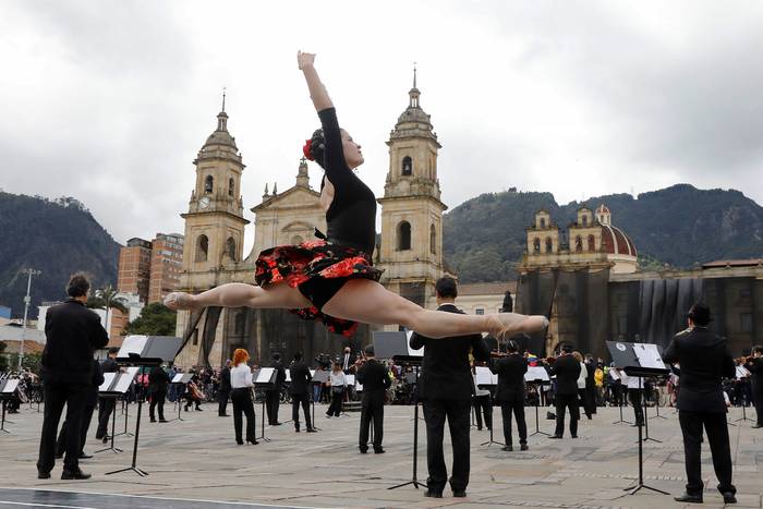 Una bailarina participa junto de la Orquesta Filarmónica de Bogotá, ayer, en la Plaza  Bolívar, para hacer un llamado para que se detenga la violencia durante las protestas en el país.
 · Foto: Carlos Ortega, EFE