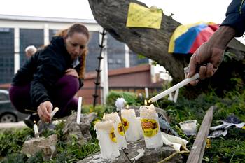 Velas en el lugar en que el senador Miguel Uribe Turbay fuera herido de bala, el 9 de junio, en Bogotá. · Foto: Raúl Arboleda, AFP