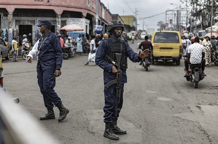 Oficiales de la policía de tráfico congoleña afiliados a los combatientes del M23 dirigen el tráfico en las carreteras que rodean el mercado de Birere, el 17 de febrero, en Goma. · Foto: Michel Lunanga, AFP