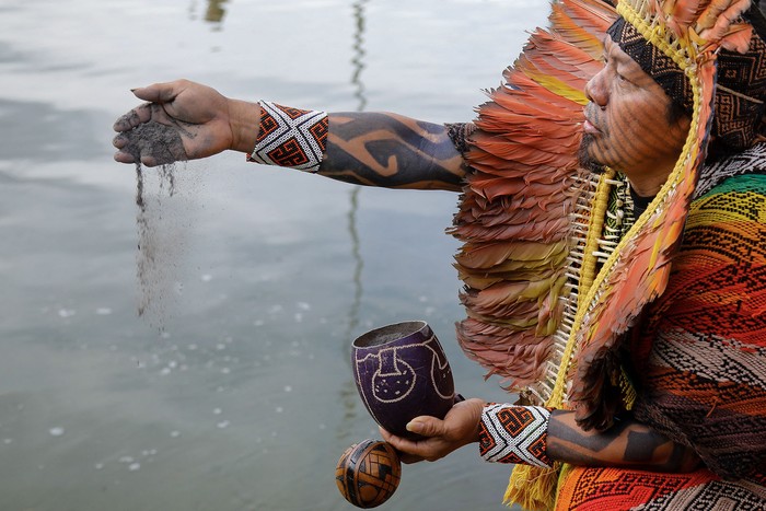 Un indígena arroja cenizas de la quema de la Amazonia en el Ministerio de Relaciones Exteriores de Brasil, el 15 de abril. · Foto: Sergio Lima, AFP