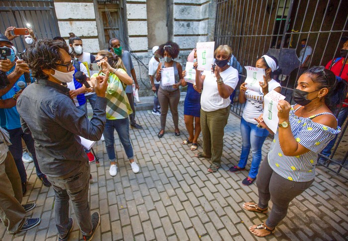 Yunior García (i) opositor cubano, habla con cinco mujeres que se manifestaron con carteles en su contra, tras salir del municipio Habana Vieja, donde le fue denegado el permiso para llevar a cabo una marcha. · Foto: Yander Zamora, EFE