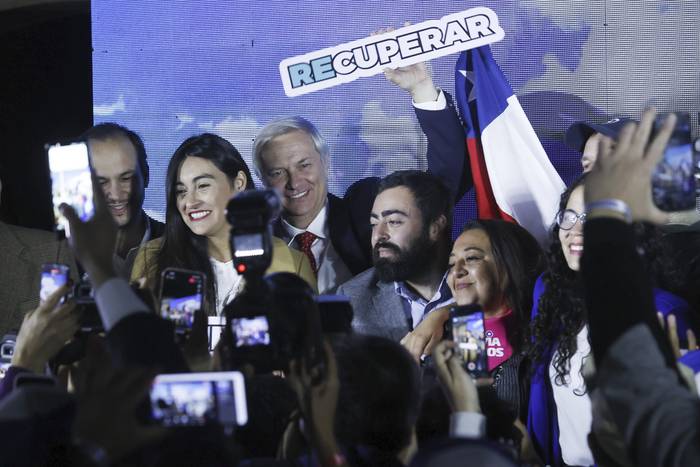 El líder del ultraderechista Partido Republicano, José Antonio Kast (c), posa para la prensa tras conocer los resultados parciales de las elecciones constituyentes, el 7 de mayo en Santiago. · Foto: Elvis González, EFE