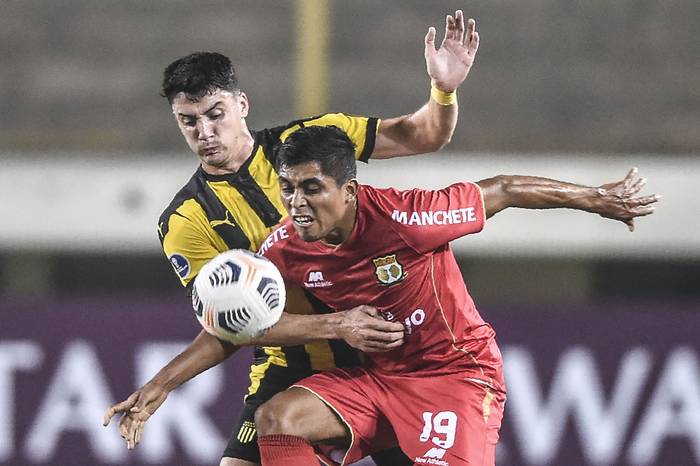 Ronal Huaccha, de Sport Huancayo, y Joaquín Piquerez, de Peñarol, durante el partido de la fase de grupos de la Copa Sudamericana, el 26 de mayo, en el Estadio Monumental de Lima. 
 · Foto: Ernesto Benavides, AFP