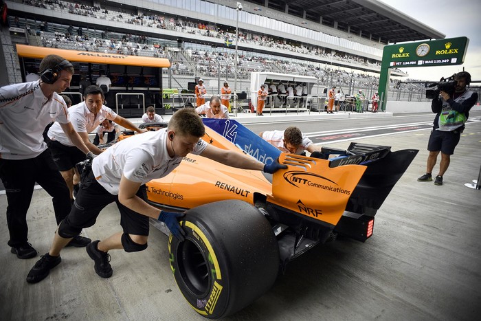 Un grupo de mecánicos empujan el McLaren de Fernando Alonso en una práctica del Gran Premio de Rusia de F1.  · Foto: Alexander Nemenov, AFP