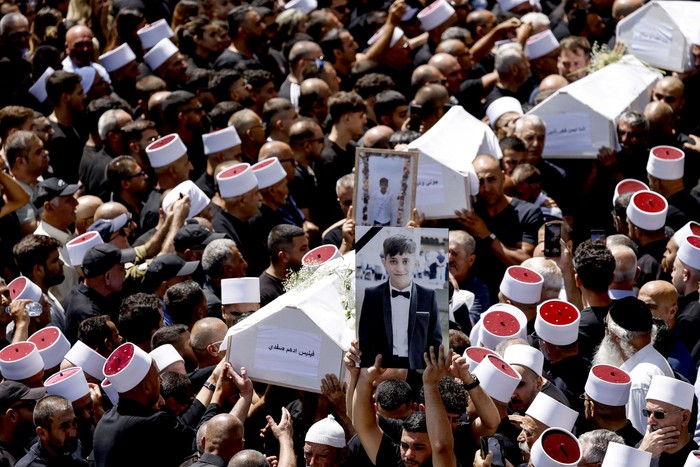 Entierro de personas que murieron en un ataque con cohetes desde Líbano, el 28 de julio, en la ciudad drusa de Majdal Shams, en los Altos del Golán anexados por Israel. · Foto: Jalaa Marey, AFP