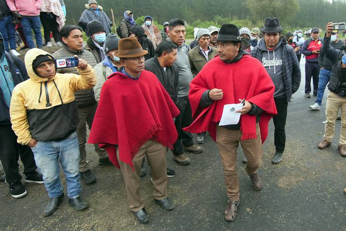 Leonidas Iza (d), presidente de la Confederación de Nacionalidades Indígenas de Ecuador, el lunes, en un camino bloqueado por indígenas y agricultores en San Juan de Pastocalle, provincia de Cotopaxi, Ecuador. · Foto: Cristina Vega, AFP