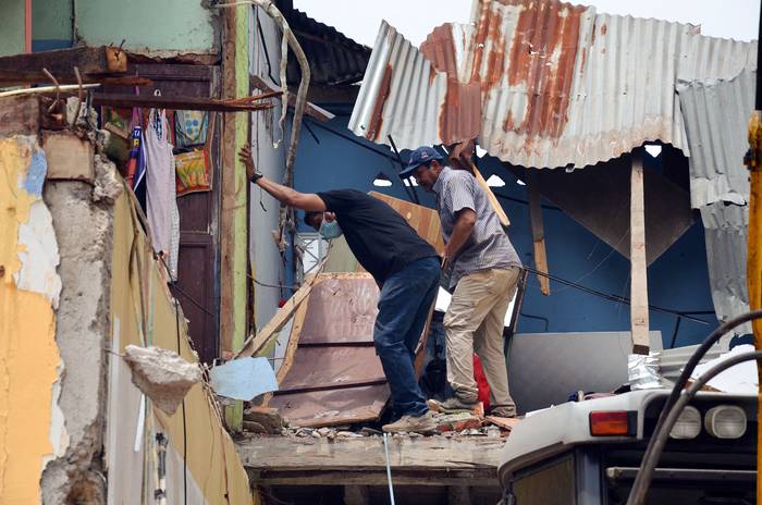 Vecinos recuperan algunas pertenencias luego del terremoto, en Machala, Ecuador (19.03.2023). · Foto: Ariel Suárez, AFP