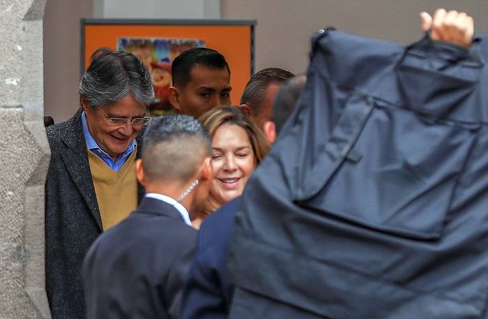 Guillermo Lasso (i), presidente de Ecuador, sale protegido con mantas antibalas, del Centro Cultural Metropolitano, en Quito, Ecuador (30.03.2023). · Foto: José Jácome, Efe