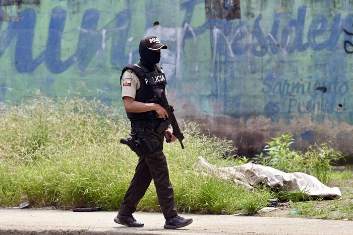 Un policía patrulla el lugar donde se encontraron los cuerpos de tres hombres desmembrados en sacos, el 18 de marzo, en Guayaquil, Ecuador. · Foto: Marcos Pin, AFP